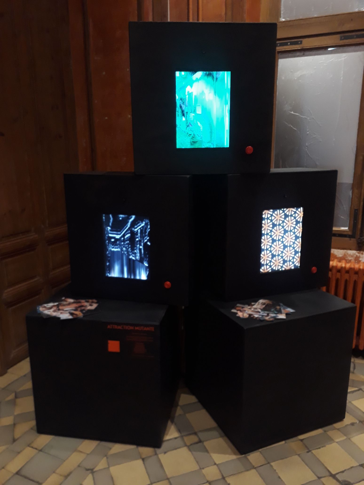 Photo de l'installation attraction mutante : 3 gros cubes noirs en bois avc des écrans intégrés